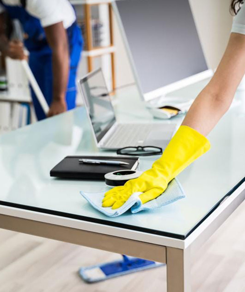 Mac's office cleaning services employee wiping office desk and cleaning