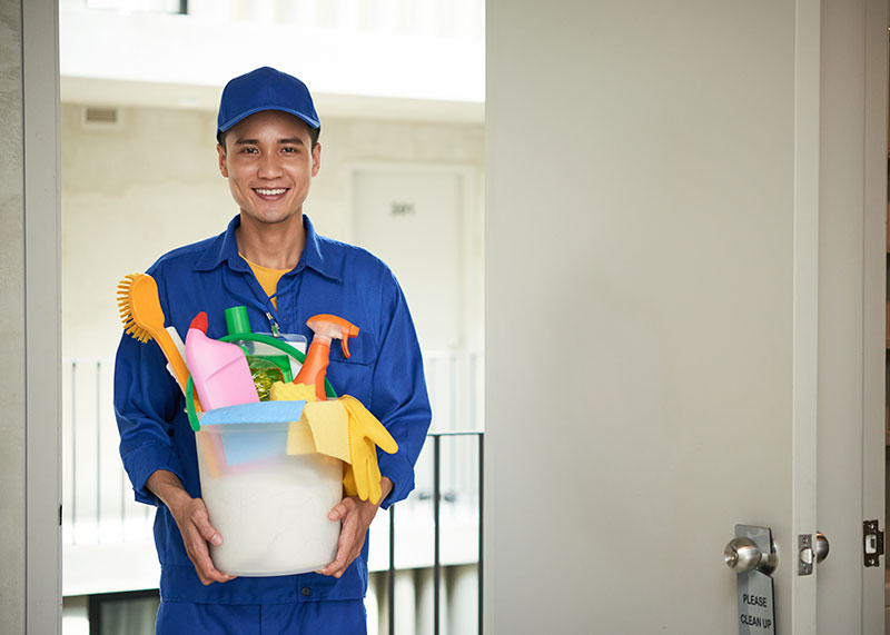 Cost-Effective Savings in floor refinishing project with Mac's employee holding bucket