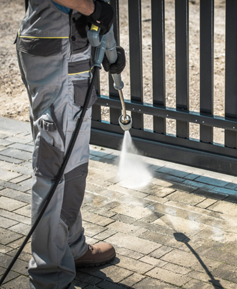 Pressure Washing ground and exterior service project of janitor power washing sidewalk