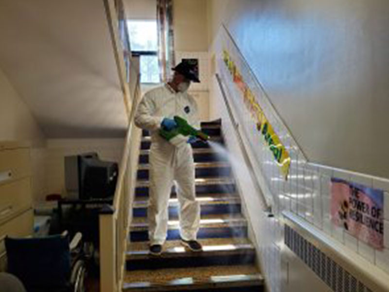 Mac's employee performing special services cleaning and sanitizing railing