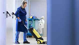 Woman cleaner vacuuming office space