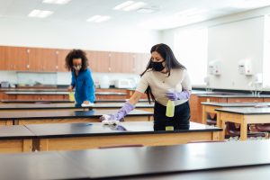 Higher education classroom and desk counters being cleaned