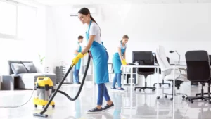 Commercial cleaning company cleaning office by vacuuming floors and wiping tables and desks