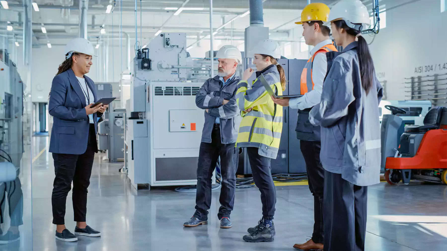 People working with hard hats in manufacturing facility