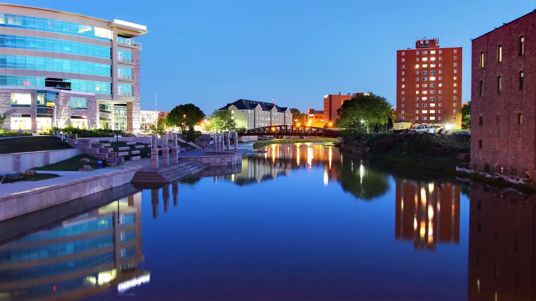 Sioux Falls, SD skyline of business district on waterfront at dusk
