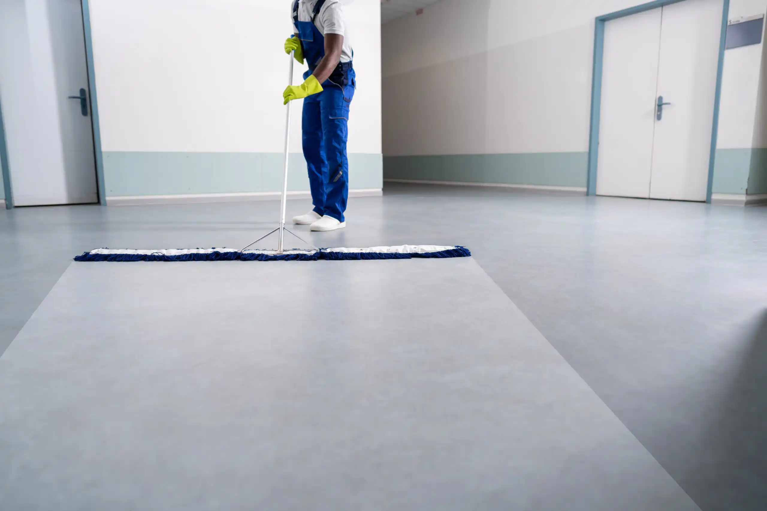 Janitor sweeping floor with large broom