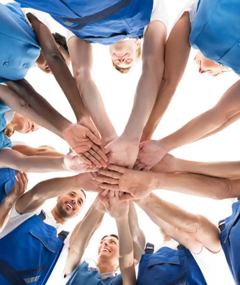 Group of people putting their hands together in a circle